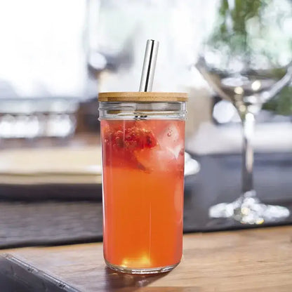 Clear glass decorbites glass boba smoothie cup with bamboo lid stainless steel straw filled with orange-red drink and ice cubes