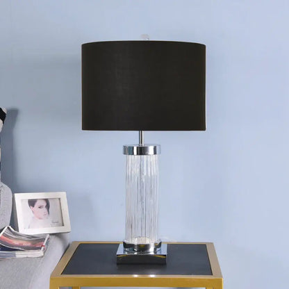 Black drum shade table lamp with clear vertically ribbed glass crystal cylinder body and chrome metal accents for bedroom
