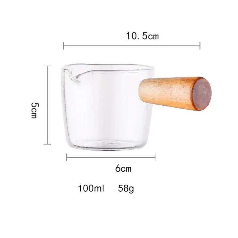 Glass espresso measuring cup with wood handle and clear glass body holding 100ml of liquid for kitchen use