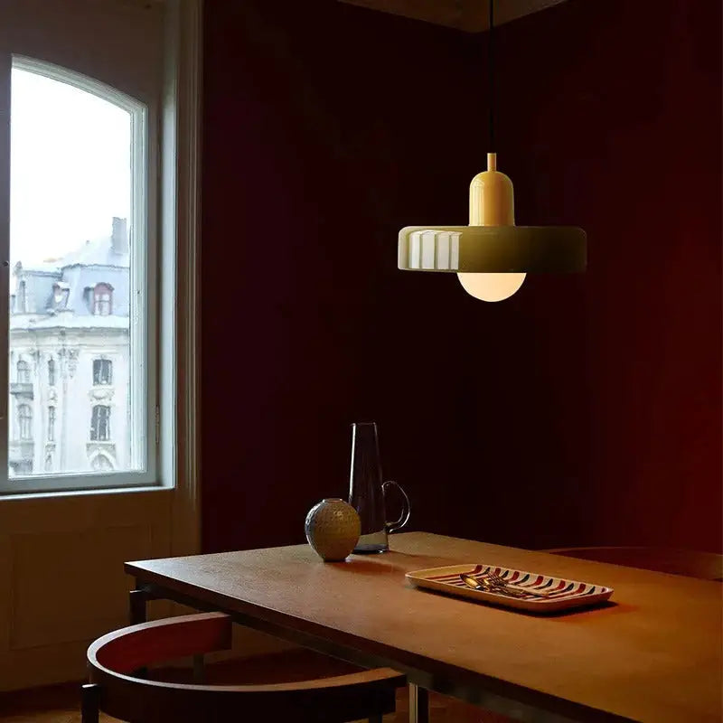 A modern glass pendant lighting bauhaus style with a matte olive green fluted shade and warm cream top section