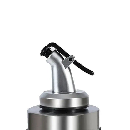 Silver metallic spray nozzle with black lever handle on glass seasoning dispenser bottle with stainless spout