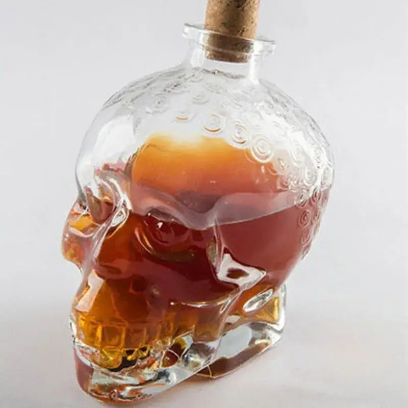 Clear glass skull bottle with cork stopper filled with amber liquid for kitchen crystal wine and vodka decanter