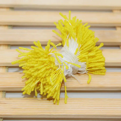 A cluster of bright yellow glittery plastic mini flower stamen picks with white stems for kids bedroom hair ties