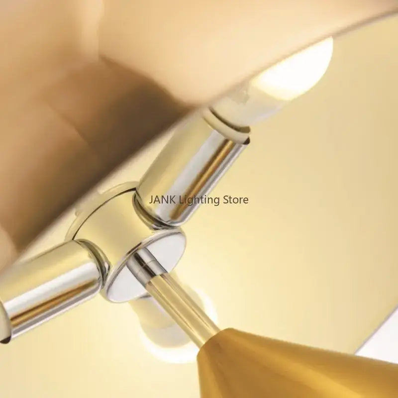 Chrome finished metal table lamp with warm glowing bulb and gold conical shade for decorbites atollo bedroom table