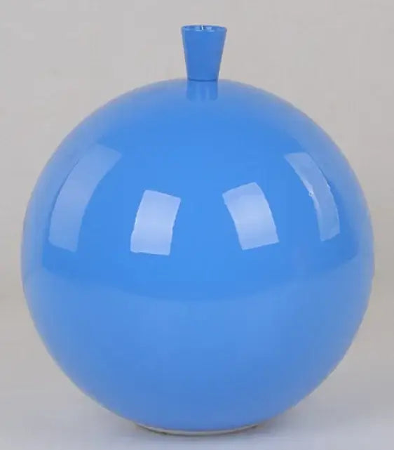A glossy vibrant blue ceramic vase with rounded body and small neck complementing a colorful balloon ceiling lamp