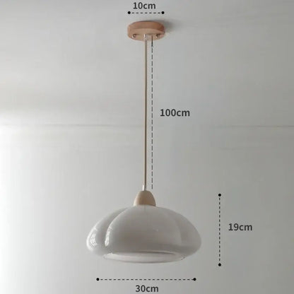 A minimalist white ceramic pendant light with wooden mount complements a glossy orange pumpkin chandelier for bedroom lighting