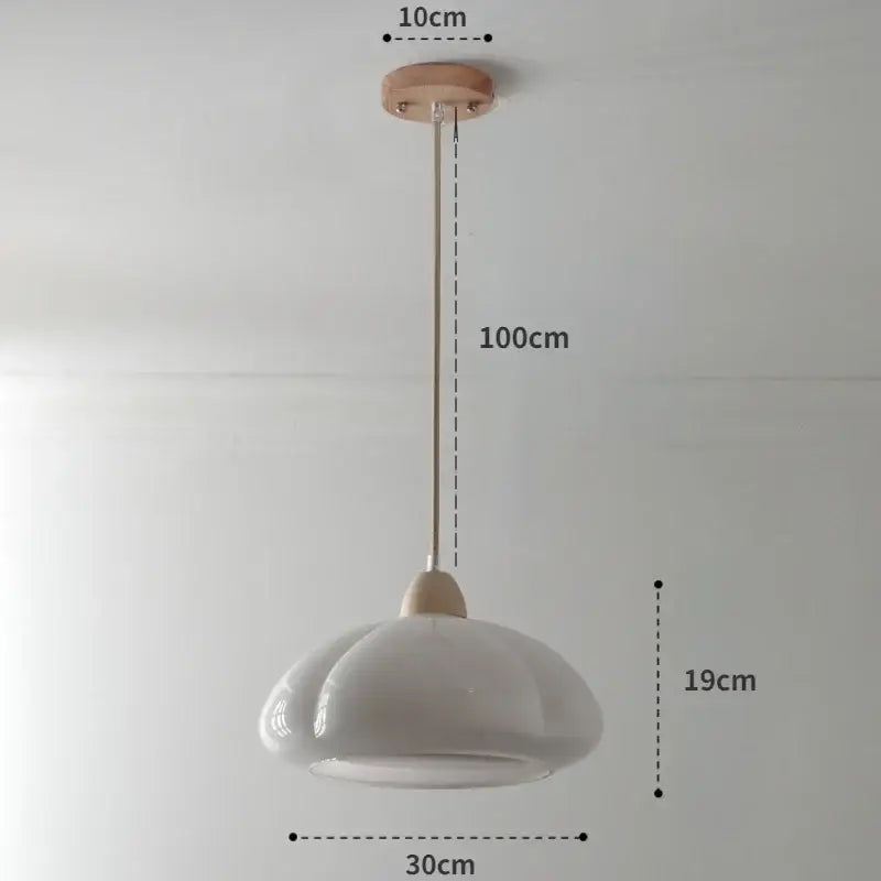 A minimalist white ceramic pendant light with wooden mount complements a glossy orange pumpkin chandelier for bedroom lighting