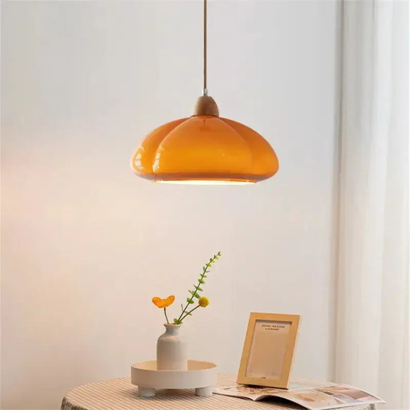 Warm amber glass pumpkin chandelier with wooden top and slender cord ideal for bedroom or restaurant balcony lighting