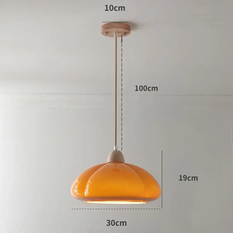 A warm amber glass pumpkin chandelier with wooden mount and metal chain ideal for bedroom or restaurant balcony lighting