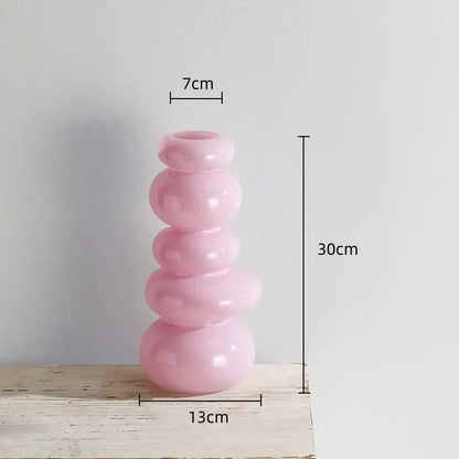 A sleek translucent pink glass vase with a stacked rounded design for a glossy pastel pebble stack floral arrangement