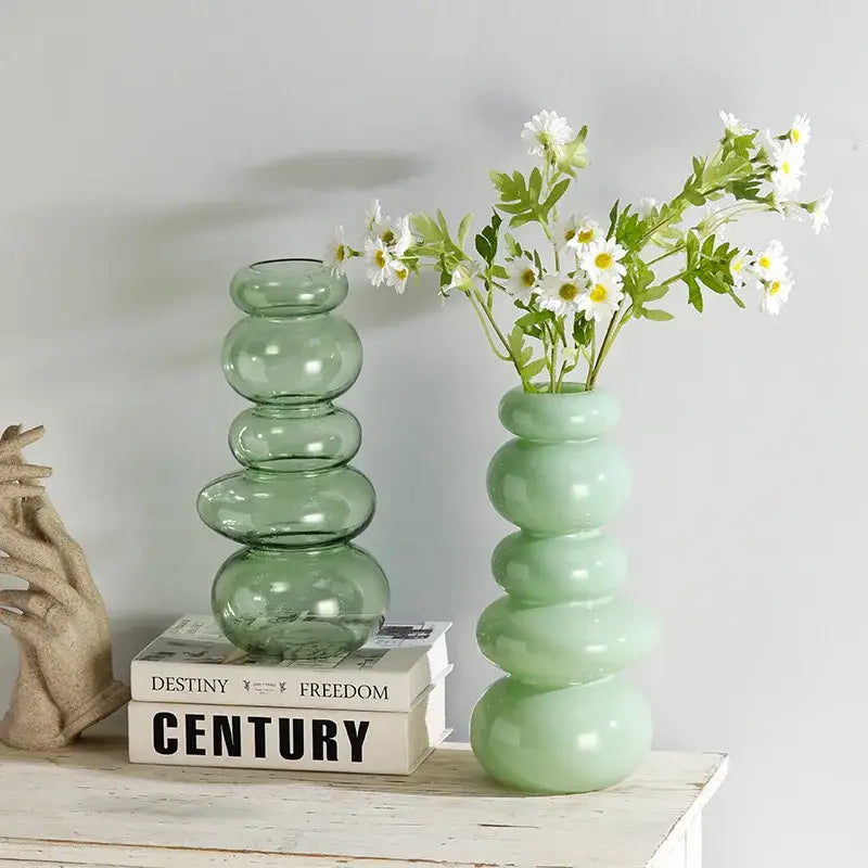 A translucent sage green glass vase with stacked rounded segments for pebble stack floral arrangement display