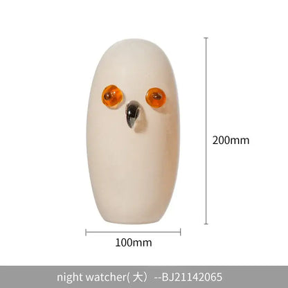 Cream-colored glass cartoon owl sculpture with amber eyes and black beak for living room home decor by decorbites