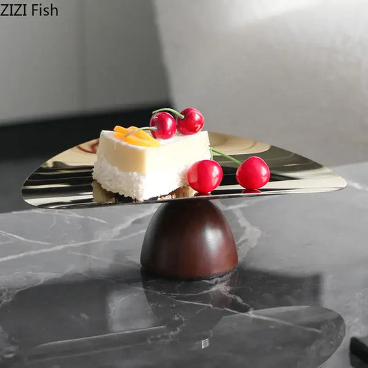 Shiny metallic gold cake stand with dark wooden base in a fruit bowl tray set for kitchen use