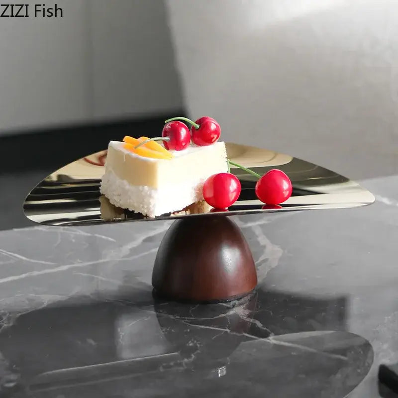 Shiny metallic gold cake stand with dark wooden base in a fruit bowl tray set for kitchen use