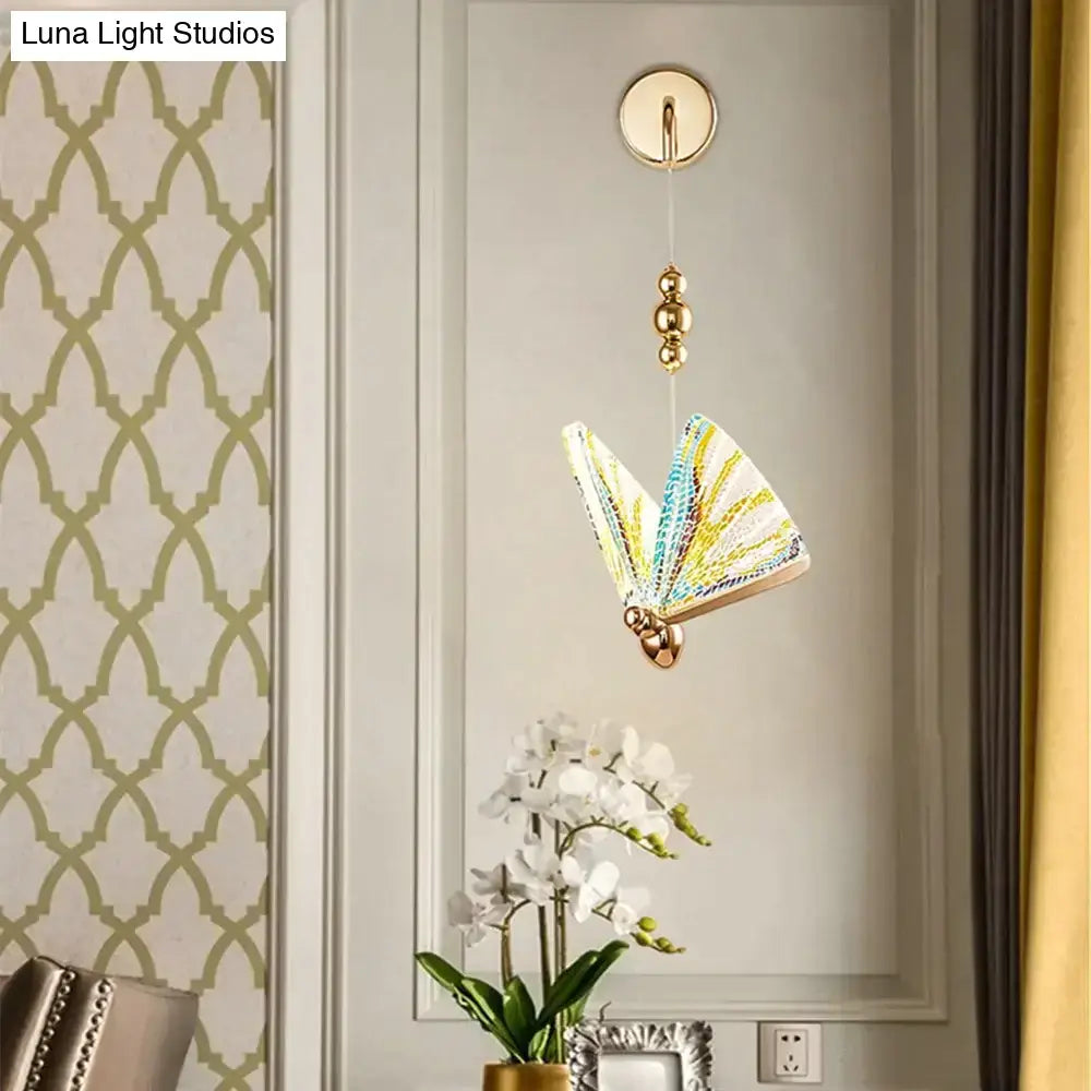 Gold and patterned butterfly led wall light with gold-toned metal frame and vibrant translucent wings for bedroom use