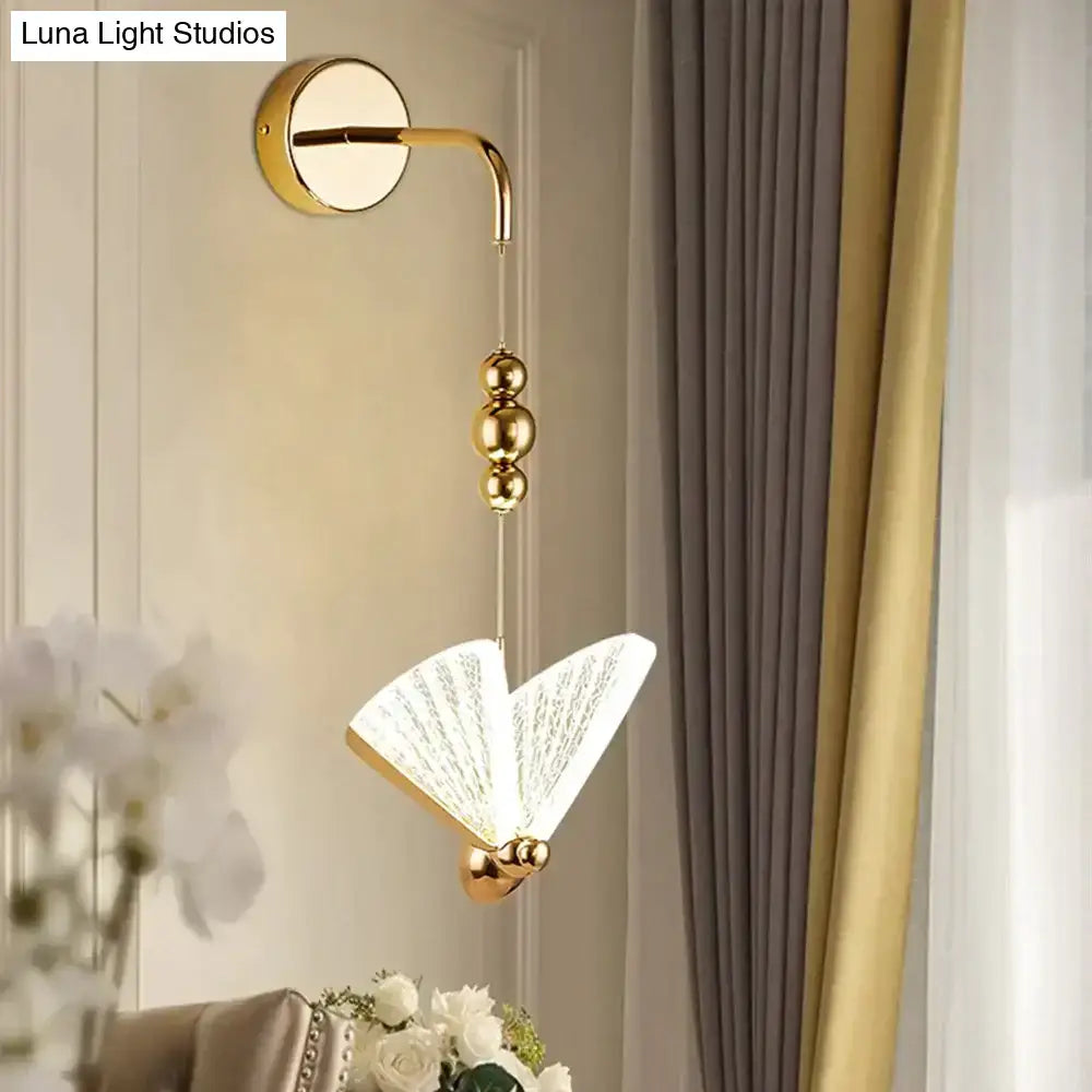Gold finished wall light with delicate fan shaped glass shade featuring intricate etched patterns for bedroom use