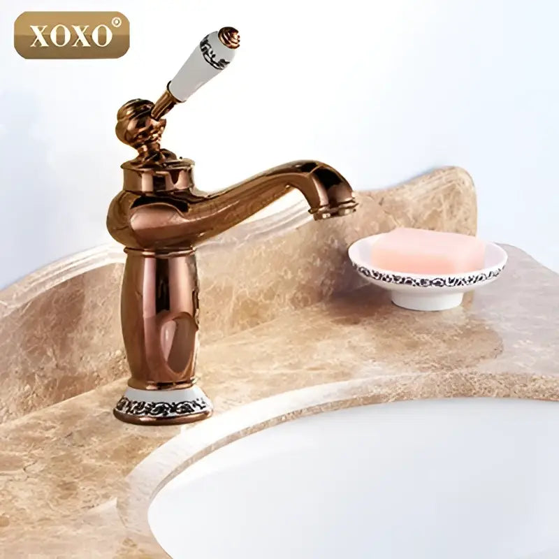 Antique brass finished deck mounted basin faucet with white ceramic handle and ornate detailing by decorbites bathroom basin