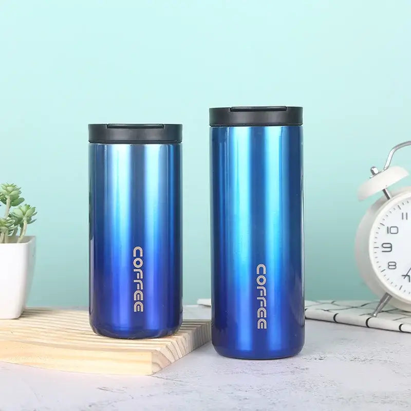 Two sleek blue gradient decorbites insulated espresso stainless steel travel mugs with black lids and silver coffee lettering