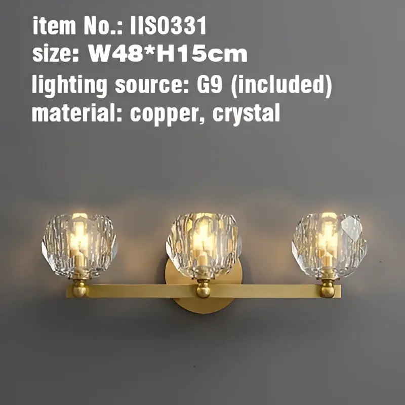 Gold-toned copper wall sconce with three faceted crystal shades for bathroom vanity light fixtures