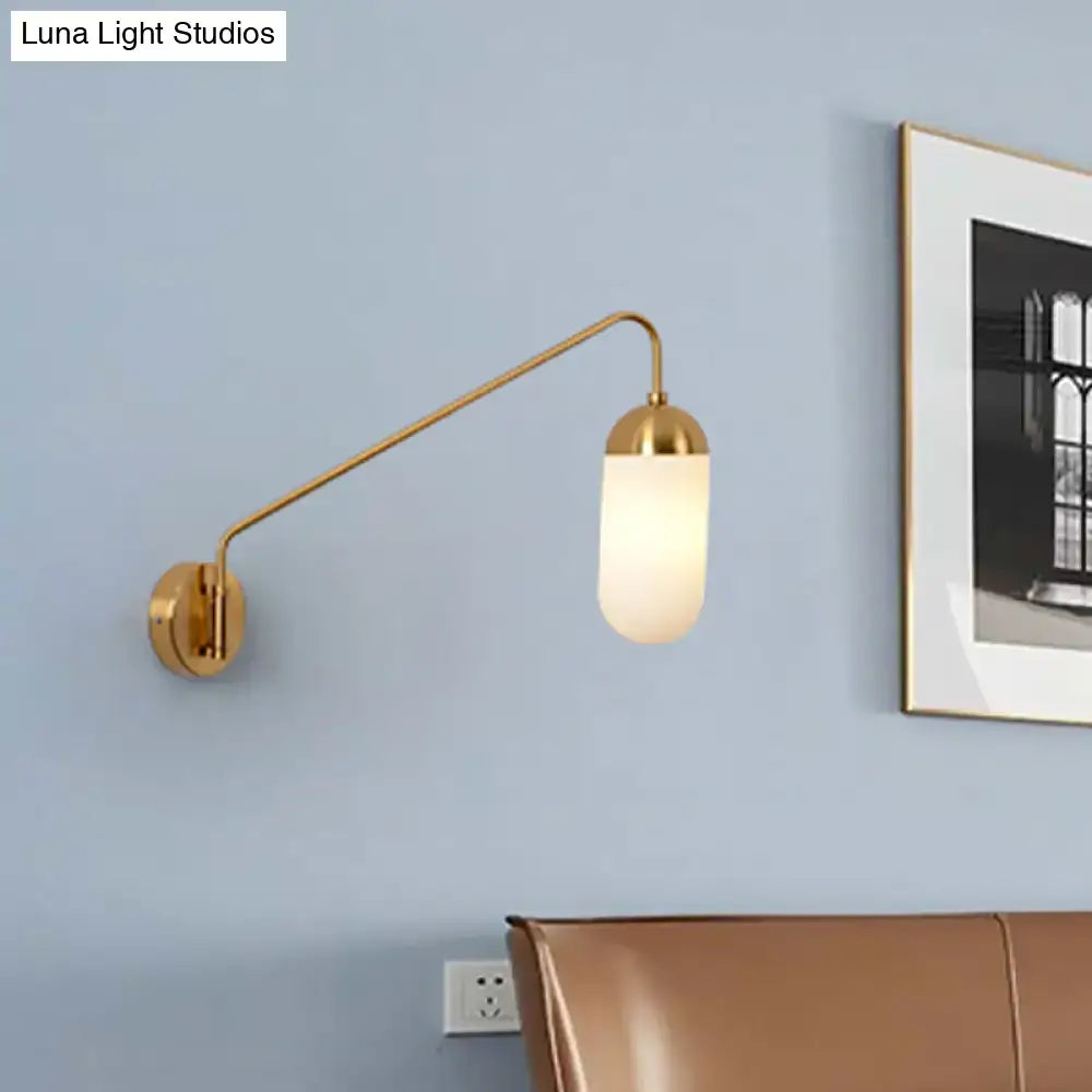 Gold brass wall lamp with a curved arm and frosted glass wall sconce designed for bedroom use