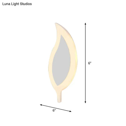 A sleek 6-inch leaf-shaped mirror with a cream frame complementing gold and brown crescent wall light for children’s bedroom