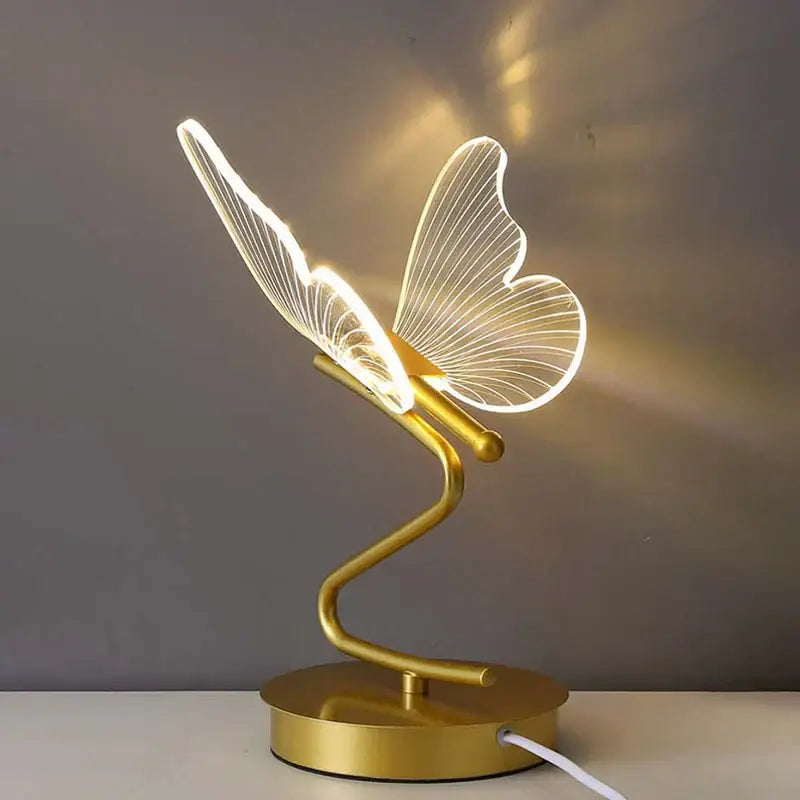 Gold butterfly led table lamp with illuminated translucent wings and sleek curved base for bedroom decorbites butterfly led decor