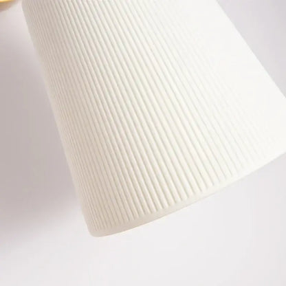 A sleek white ribbed fabric shade on a gold ceramic led wall lamp by decorbites for living room decor