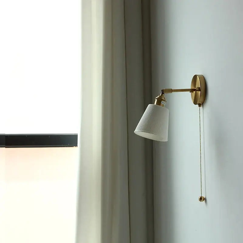 Gold ceramic led wall sconce with ribbed white ceramic shade and pull chain by decorbites for bedroom decor