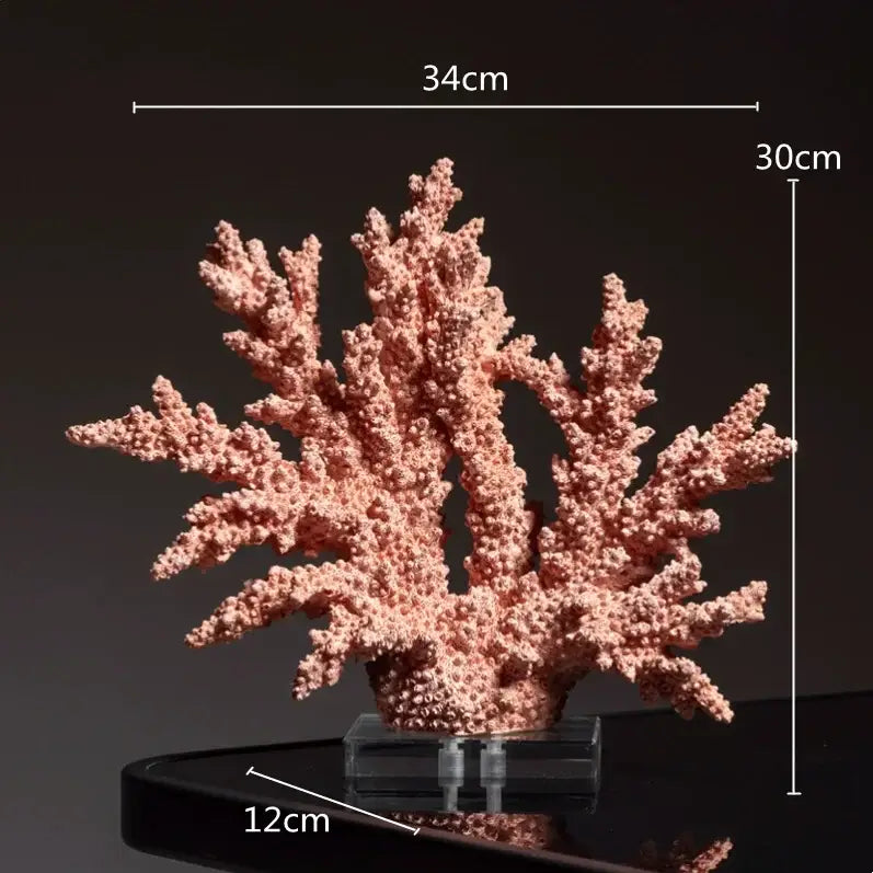 A delicate pink coral crystal tree sculpture with textured branches on a clear acrylic base for living room decor