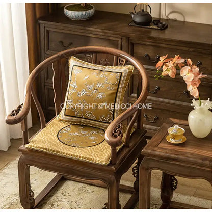 Elegant gold silk lumbar pillow case with intricate white embroidery of crane birds branches on wooden chair
