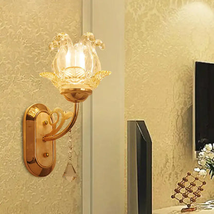 Gold-toned wall lamp with clear glass lotus-shaped shade and crystal droplet featuring simplicity blossom design and fixture width