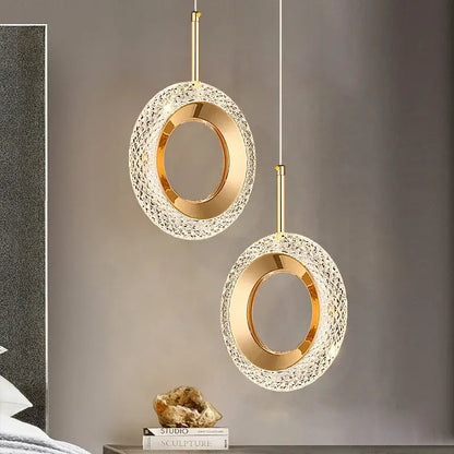 Gold-toned led pendant light with textured crystal-encrusted outer ring and smooth inner band for luxury dining room chandelier
