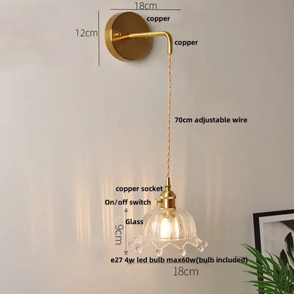 A brass-finished copper wall light with clear glass petal-shaped shade and adjustable 70cm wire for decorbites clear glass led lighting