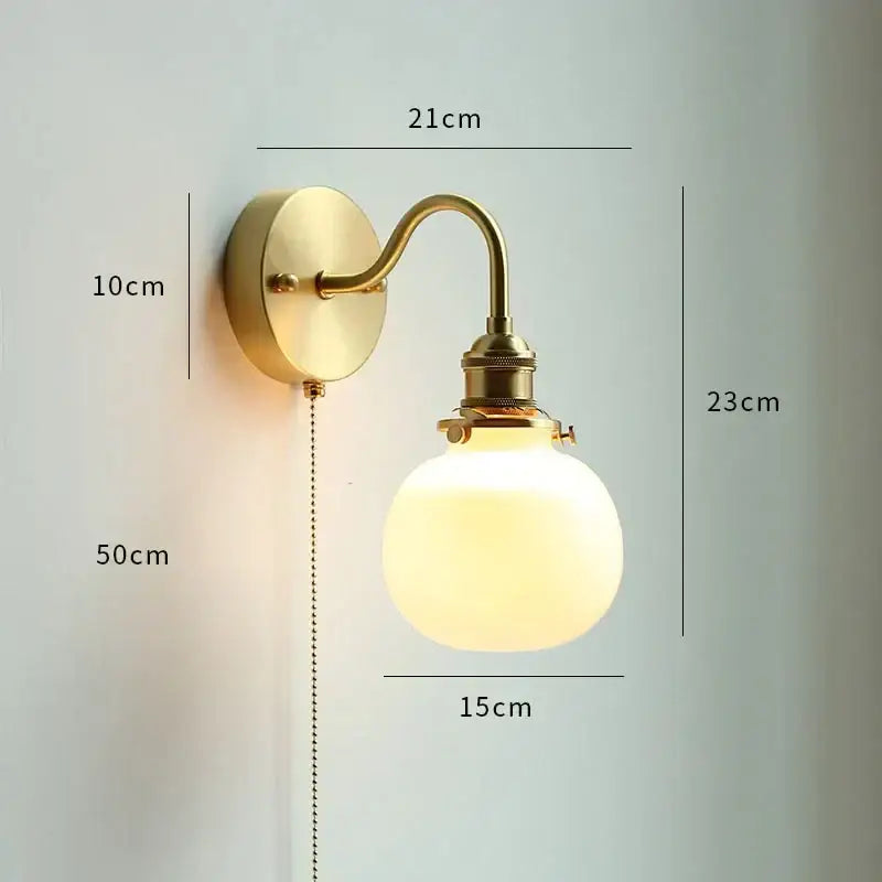 Brass-finished gold fluted glass wall sconce with frosted globe and curved arm for elegant bedroom wall lamp decorbites copper wall