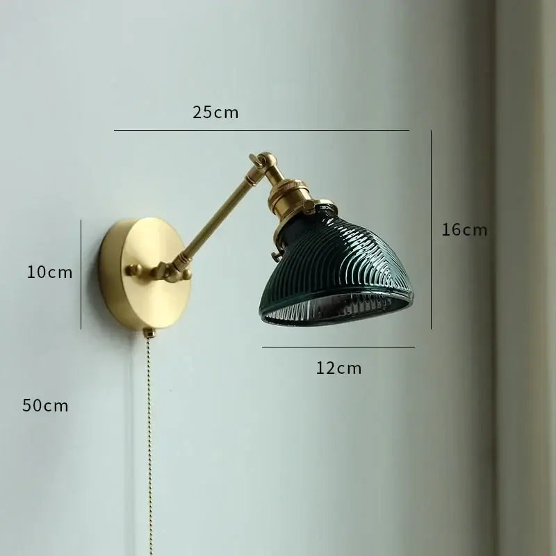 A vintage brass wall sconce with a dark green ribbed glass shade and adjustable arm decorbites copper wall lamp