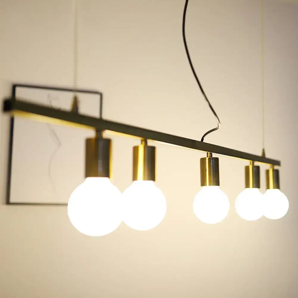 Modern industrial gold linear island pendant light with black metal bar and five white bulbs in polished brass sockets