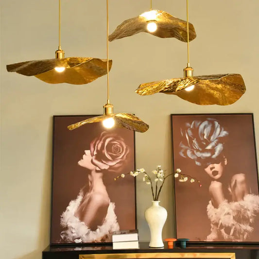 Three gold lotus leaf pendant lights with textured surfaces by decorbites for elegant living room decor