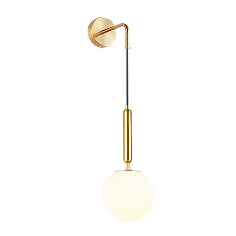 Gold-toned light fixture with a sleek curved arm, black cable, and frosted opal glass spherical shade for bedroom use