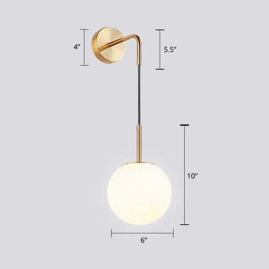 Gold-toned light fixture with a sleek curved arm and frosted opal glass spherical shade for bedroom wall mounting
