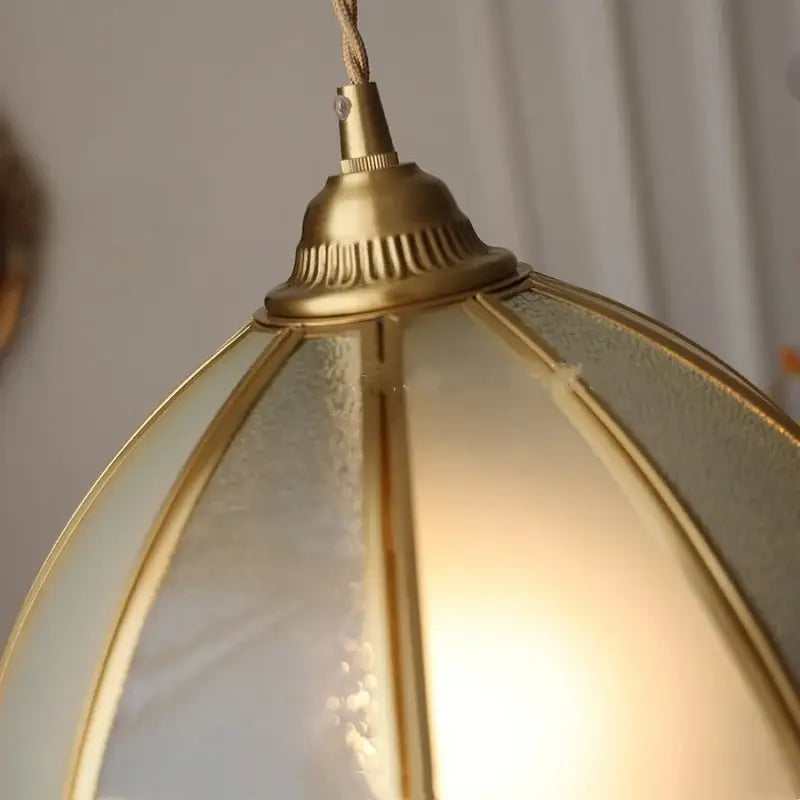 Gold-toned brass glass led pendant lamp with frosted glass panels and warm textured glow for kitchen lighting