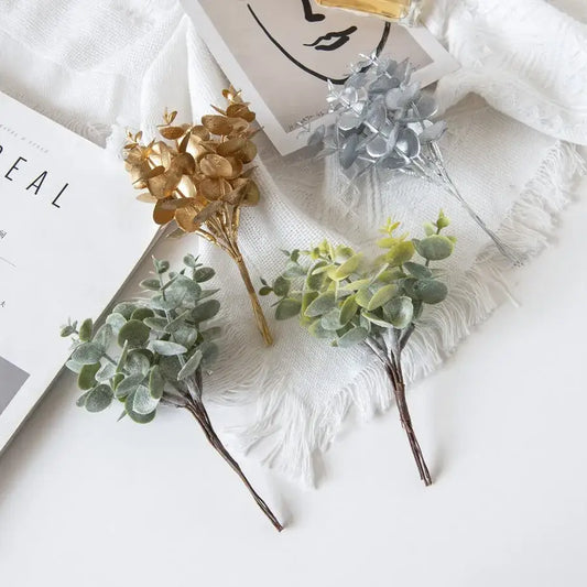 Four artificial eucalyptus leaves sprigs in gold silver and green with textured leaves and dark brown stems for decorbites decor