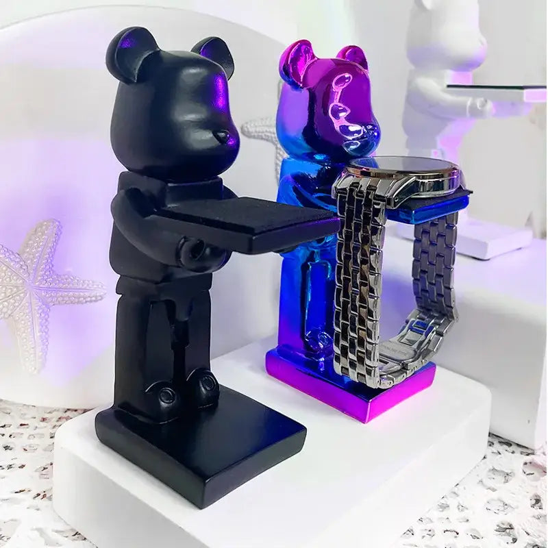 Black and iridescent purple bear statue watch rack with glossy resin finish holding a silver-toned bracelet