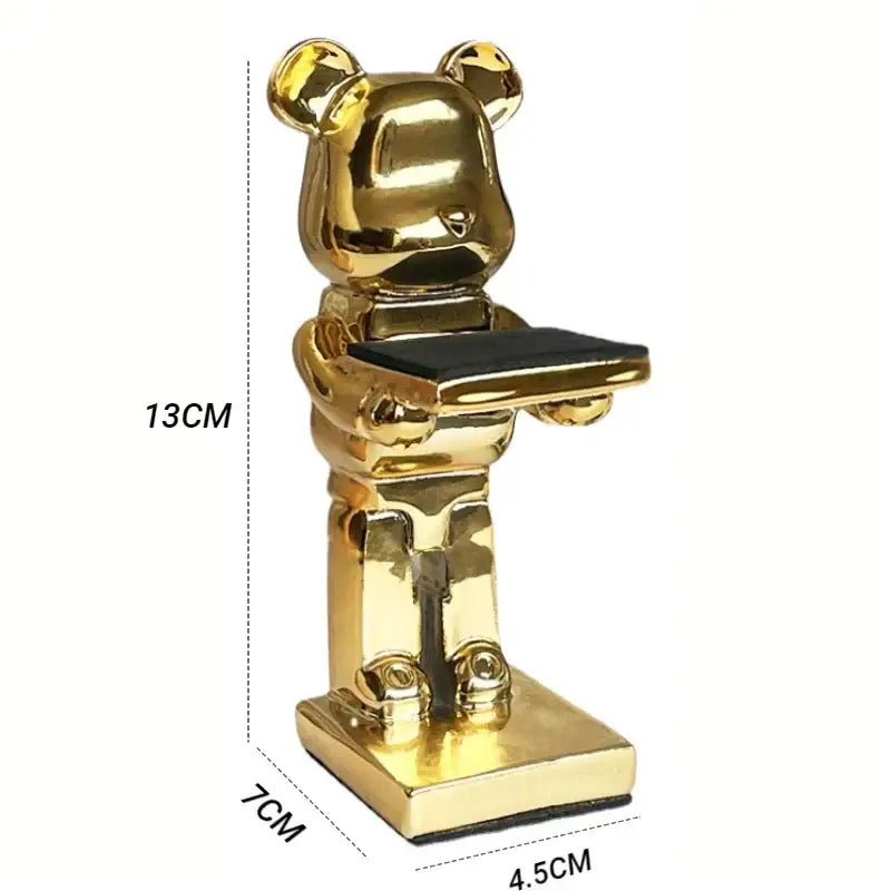 Golden bear statue watch rack with sleek reflective finish holding a black tray for bedroom storage and organization