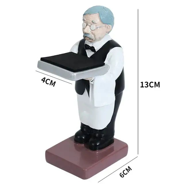 A miniature resin figurine of a vintage waiter with light blue hair holding a silver tray for bear statue watch rack