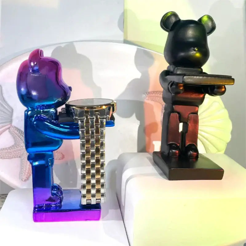 Vibrant iridescent blue and purple bear statue watch rack holding gold and silver-toned watch for bedroom storage