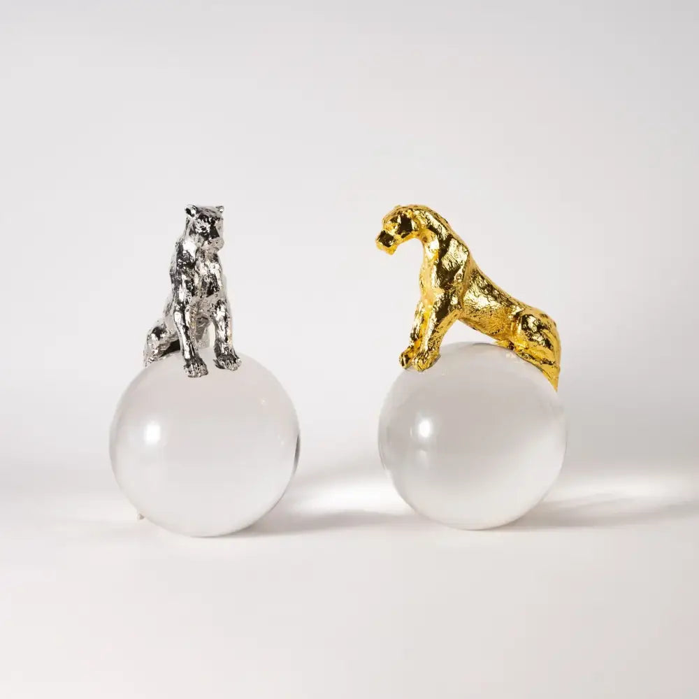 Two metallic panther figurines in gold and silver perched on translucent spheres for leopard crystal ball decorbites decor