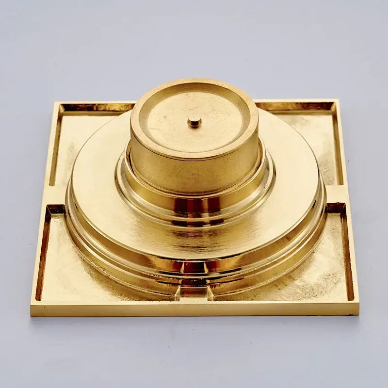 Golden brass decorbites gold square bathroom shower drain with square base and concentric circular tiers and interchangeable grates