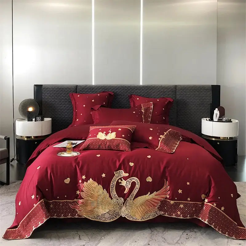Luxurious burgundy satin bedding set with intricate gold embroidered swan motifs by DecorBites gold swan love design