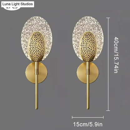 Gold finished led wall lamp with intricate textured glass panels and circular base for indoor lighting in bedroom