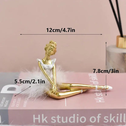 Golden and white ballet girl resin figurine with tutu and feather trim seated as bedroom desktop decor